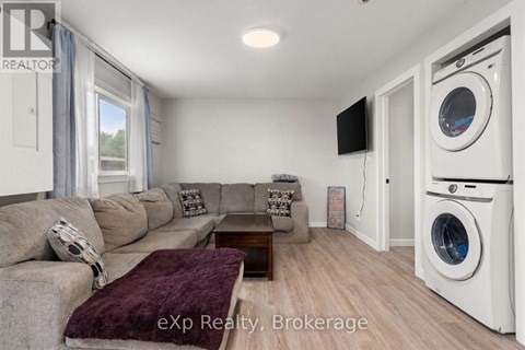A living room with a couch, a coffee table, and a washing machine in the corner.