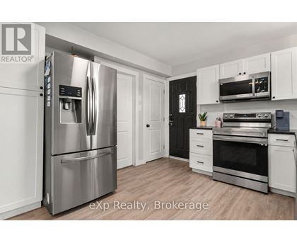 A modern kitchen with a stainless steel refrigerator and oven.