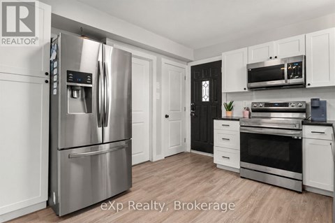 A modern kitchen with a stainless steel refrigerator and oven.