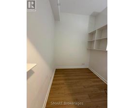 A room with wooden flooring and white walls.