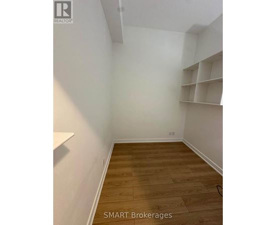 A room with wooden flooring and white walls.