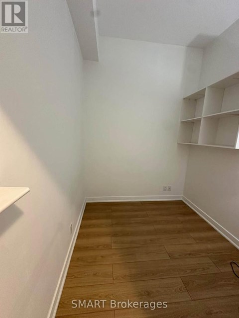 A room with wooden flooring and white walls.