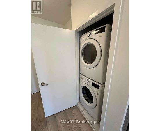 A washing machine is built into a wall in a laundry room.