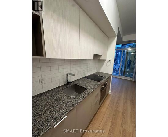 A modern kitchen with granite countertops and white cabinets.