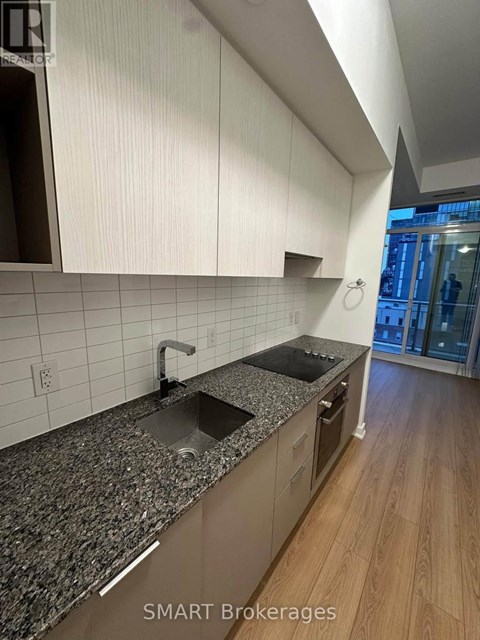 A modern kitchen with granite countertops and white cabinets.