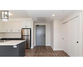 A kitchen with white cabinets and a stainless steel refrigerator.