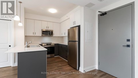 A modern kitchen with a refrigerator, microwave, and oven.