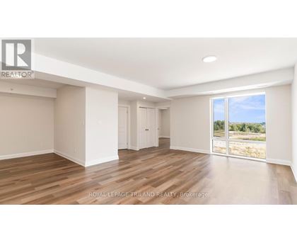 A spacious room with wooden flooring and white walls.
