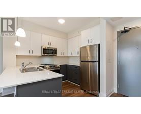 A kitchen with a white counter top and stainless steel appliances.