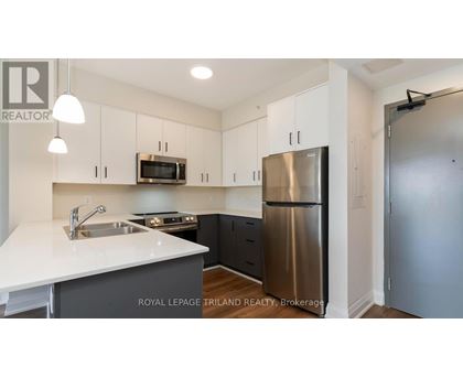 A kitchen with a white counter top and stainless steel appliances.