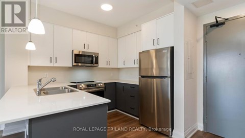 A kitchen with a white counter top and stainless steel appliances.