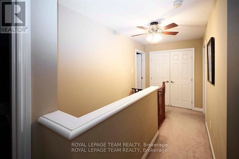 A room with a ceiling fan and a bed.
