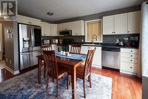 A kitchen with a table and chairs in front of a refrigerator.