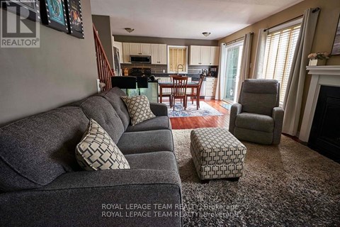 A living room with a grey couch and a fireplace.