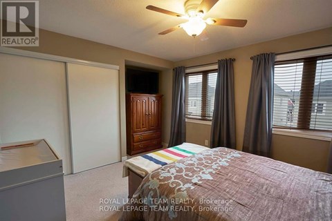 A bedroom with a bed, dresser, and sliding door.
