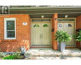 A red brick house with a white door and a window.