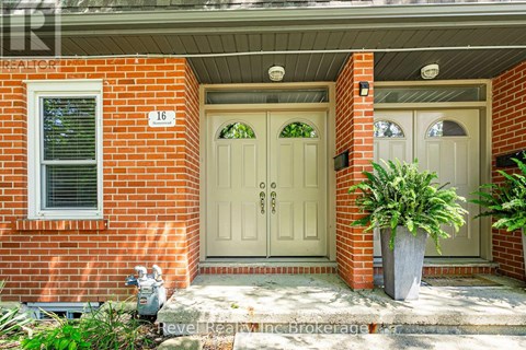 A red brick house with a white door and a window.