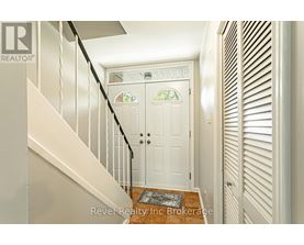 A white door with a glass window is at the end of a hallway.
