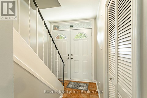 A white door with a glass window is at the end of a hallway.