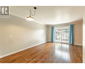 A room with wooden flooring and a window with blue curtains.