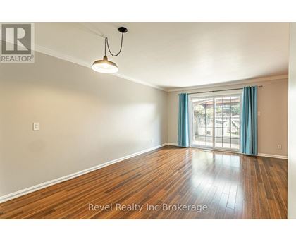 A room with wooden flooring and a window with blue curtains.