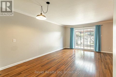 A room with wooden flooring and a window with blue curtains.