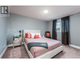 A bedroom with a bed, nightstand, and window.