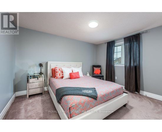 A bedroom with a bed, nightstand, and window.