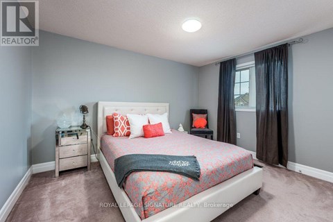 A bedroom with a bed, nightstand, and window.