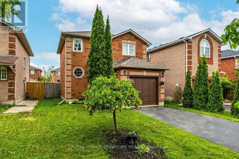 A house with a brown brick exterior and a tree in front of it.