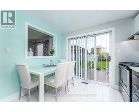 A dining room with a table and chairs and a sliding glass door.