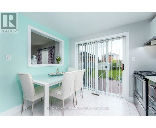 A dining room with a table and chairs and a sliding glass door.