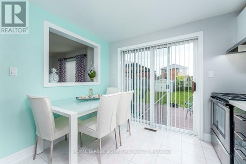A dining room with a table and chairs and a sliding glass door.
