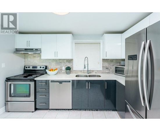 A modern kitchen with stainless steel appliances and white cabinets.