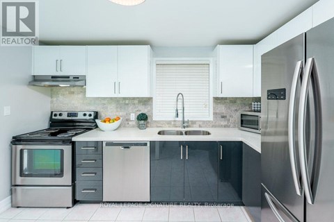 A modern kitchen with stainless steel appliances and white cabinets.