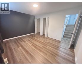 A room with wooden flooring and white walls.
