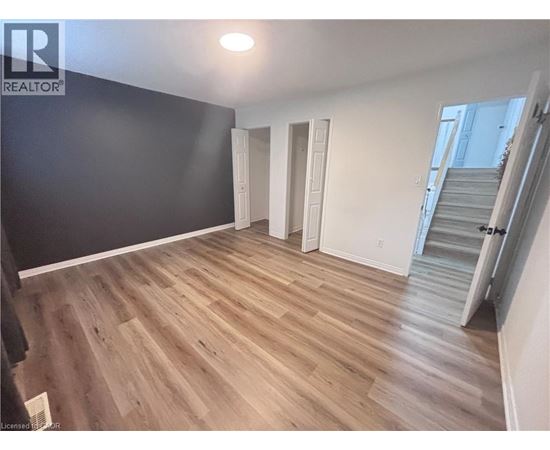 A room with wooden flooring and white walls.