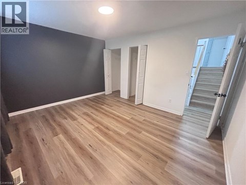 A room with wooden flooring and white walls.