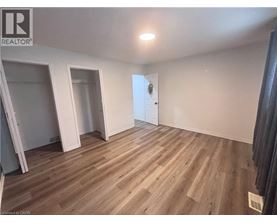 A room with wooden flooring and a door in the background.