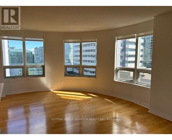 A room with wooden floors and windows overlooking a cityscape.