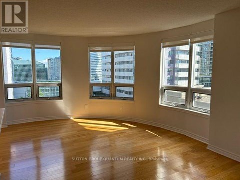 A room with wooden floors and windows overlooking a cityscape.