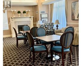 A dining room with a fireplace and a table set for six.