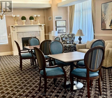 A dining room with a fireplace and a table set for six.