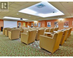 A conference room with rows of chairs and a projector screen.