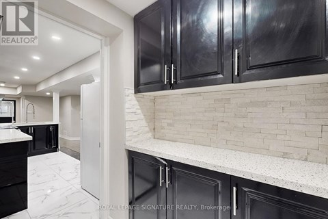 A kitchen with black cabinets and a white countertop.