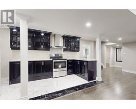 A modern kitchen with black cabinets and stainless steel appliances.