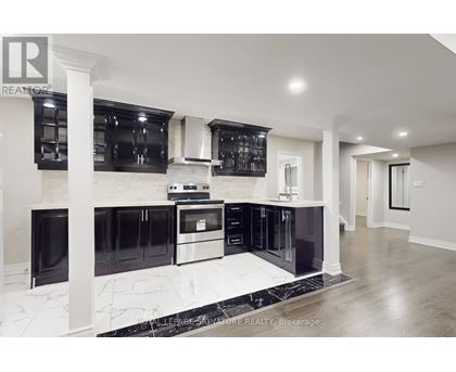 A modern kitchen with black cabinets and stainless steel appliances.