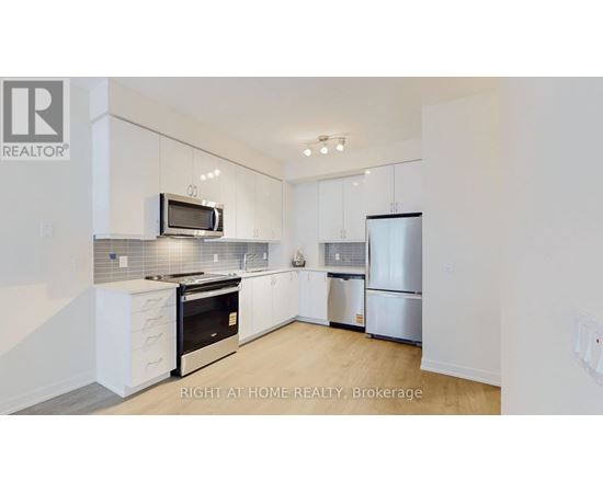 A modern kitchen with white cabinets and stainless steel appliances.