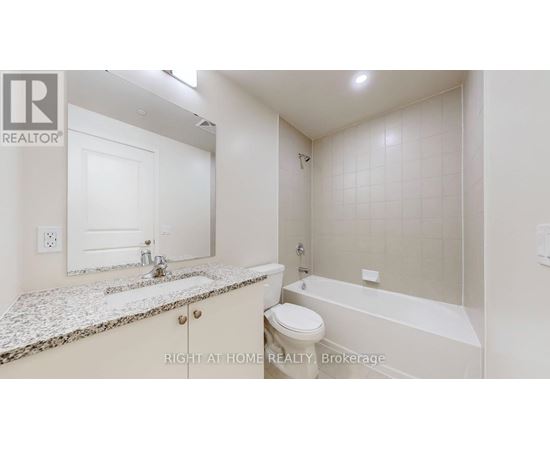 A white bathroom with a marble countertop and a bathtub.