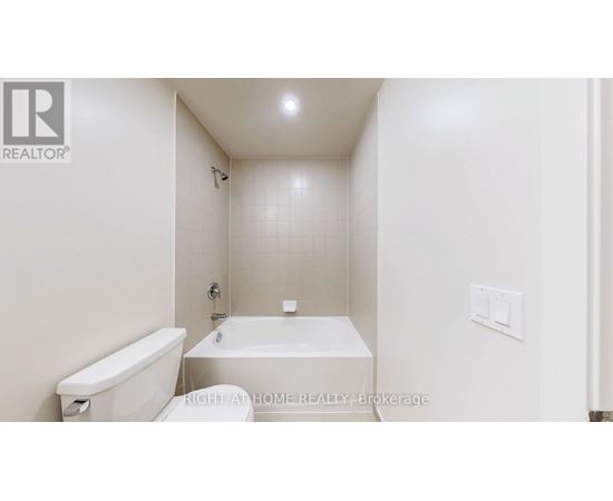 A white bathroom with a tub, toilet and sink.